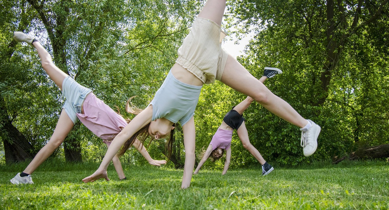 Studentky dělají hvězdy na trávě ve školním areálu